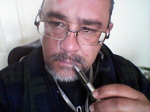 El autor luce encabronadamente guapo mientras aspira su pipa de vapor enfundado en la bata que le obsequió el mismísimo Mauricio Garcés.